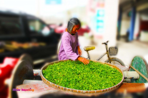 A Chinese lady selling veggies outside the restaurant in Xinchang